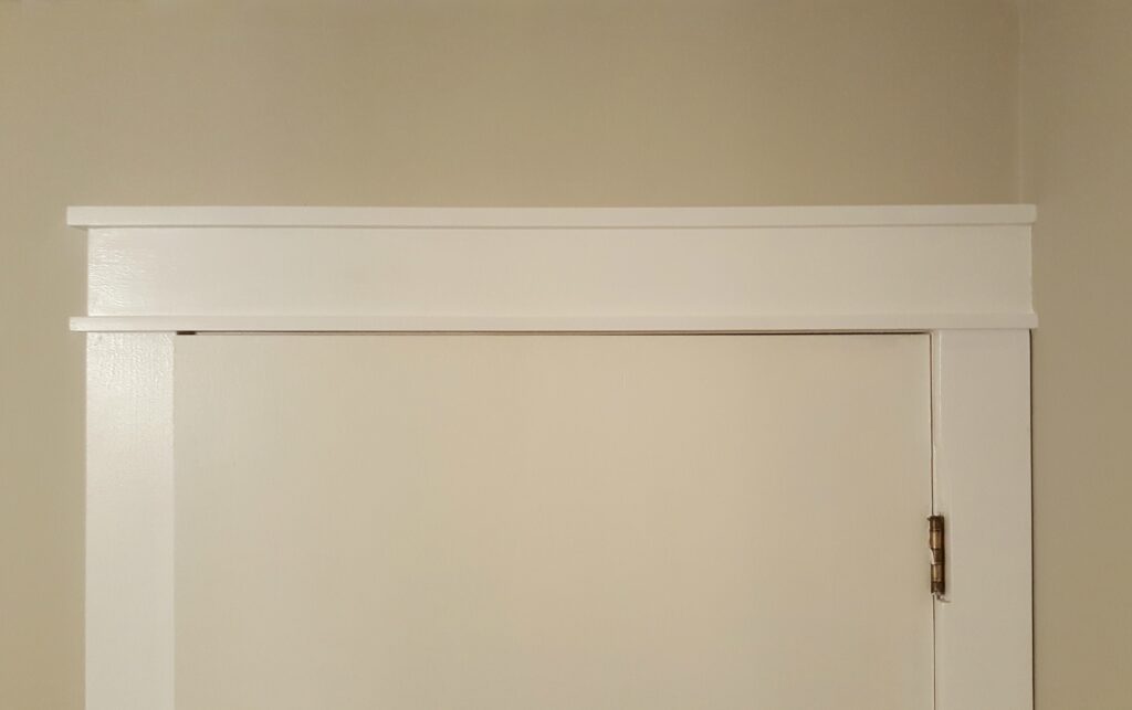 White Craftsman-style door casing and trim against a light beige wall.