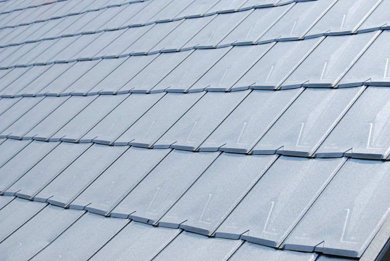 Overlapping gray metal roof shingles.