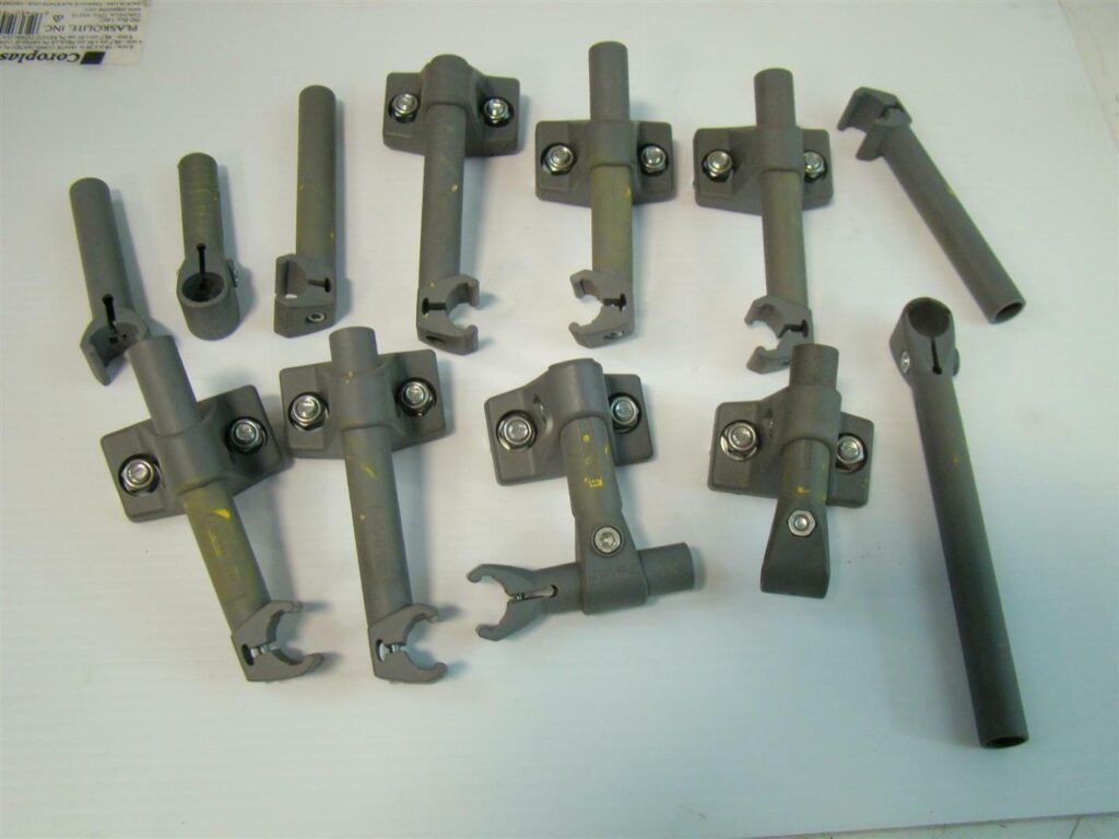 Collection of grey plastic mounting brackets and hardware components arranged on a white surface.
