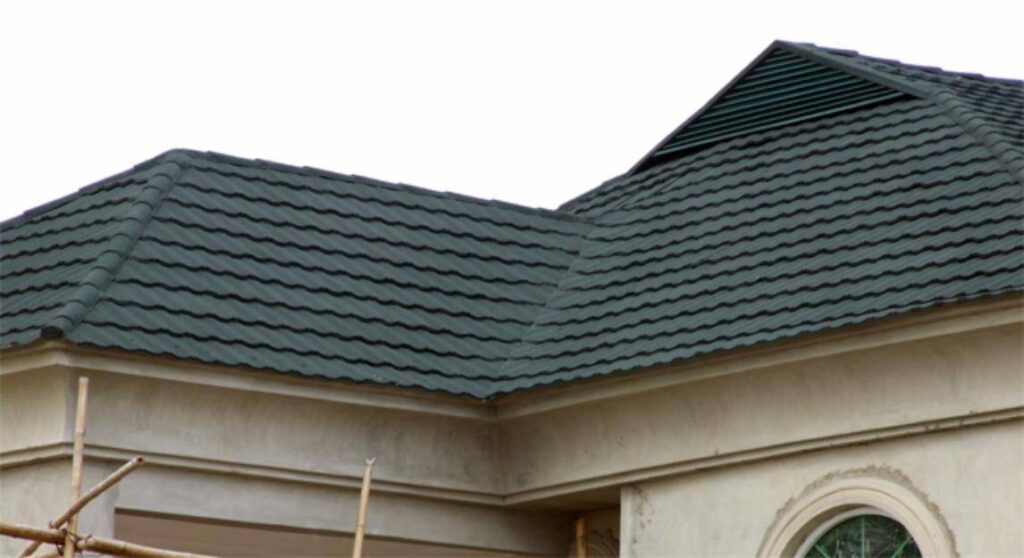 Dark grey wavy metal roof tiles on a light beige building.