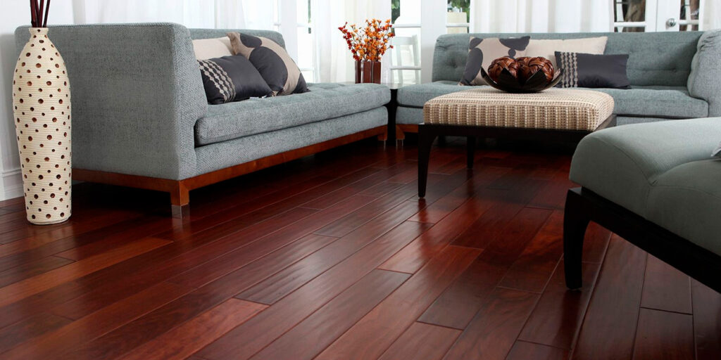 Modern living room with polished dark red hardwood floors and light blue sofas.