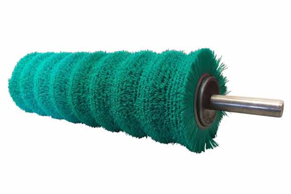 A cylindrical industrial brush roller with green bristles and a central metal shaft.