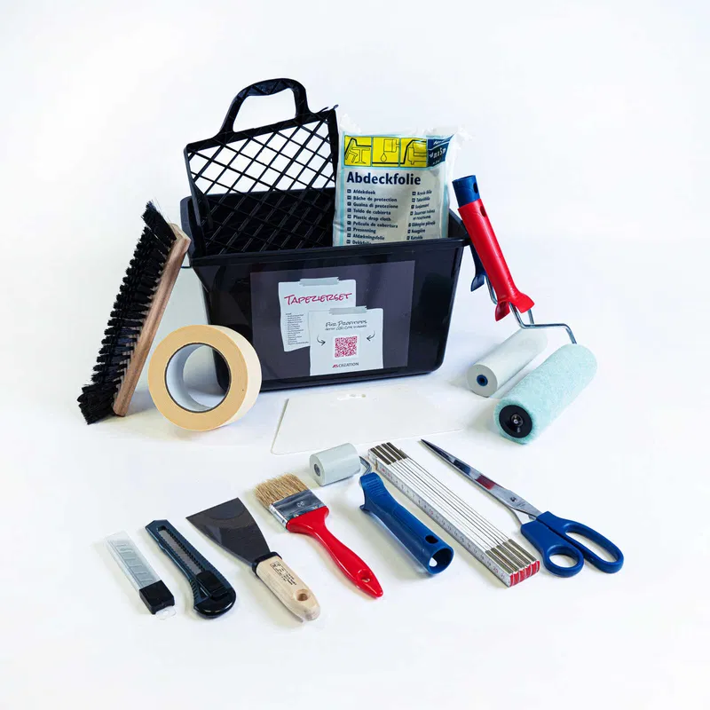 A black toolbox filled with various painting and wallpapering tools, including brushes, rollers, scissors, and tape.