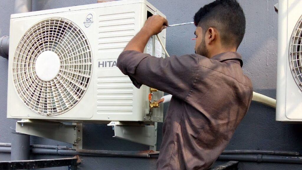 Technician repairing an outdoor air conditioning unit.