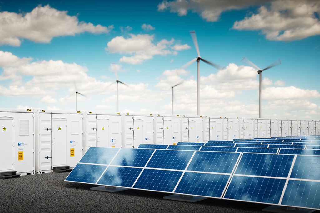 Renewable energy farm featuring solar panels, battery storage units, and wind turbines under a cloudy blue sky.