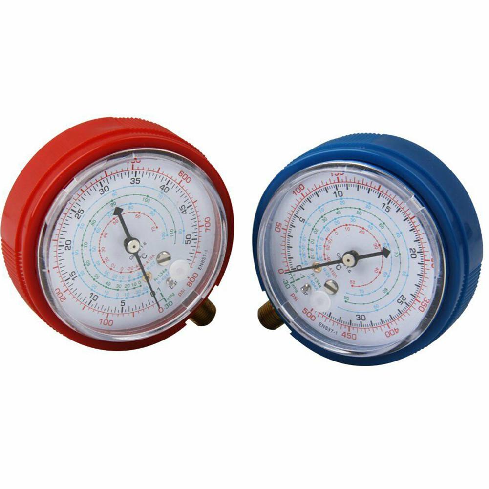 Red and blue HVAC pressure gauges with white measurement dials.