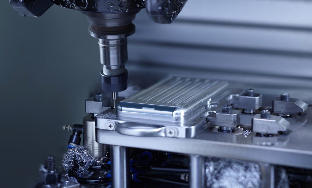 A CNC milling machine precision-carving a metallic phone casing.
