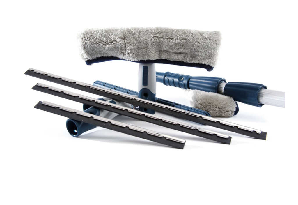 Window cleaning tools including a microfiber scrubber, a squeegee, and several replacement blade strips.