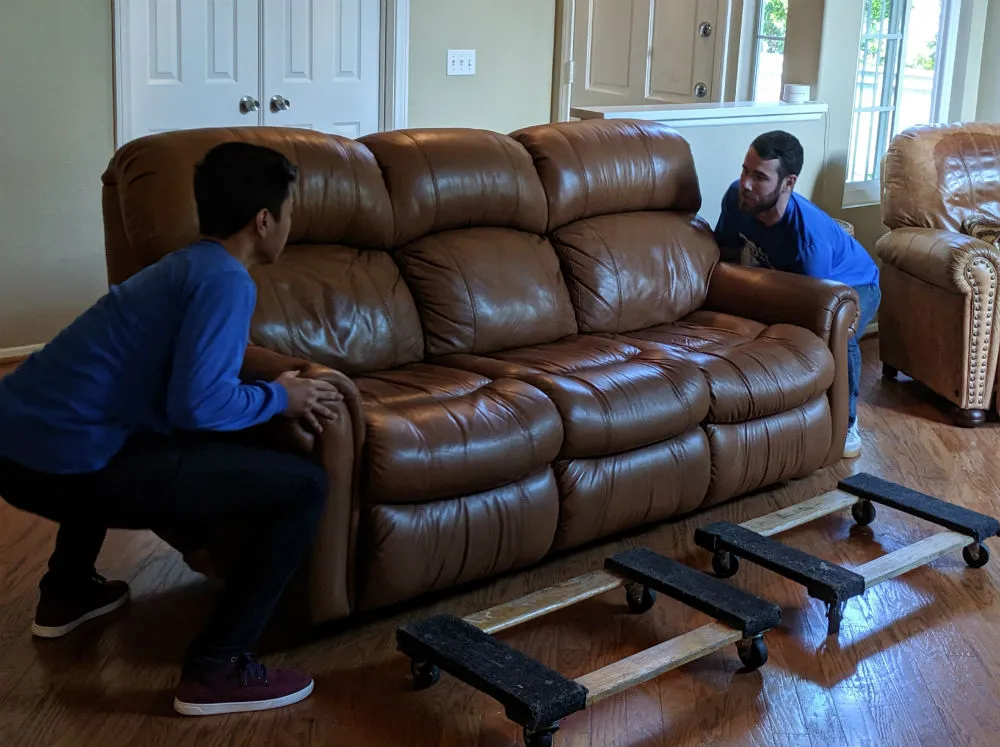 How to Move a Couch or Sofa Two Delivery professionals picking up a couch