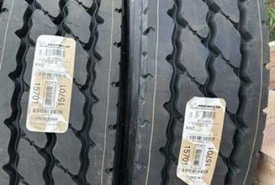 Two Michelin commercial tires with deep treads and white identification tags.