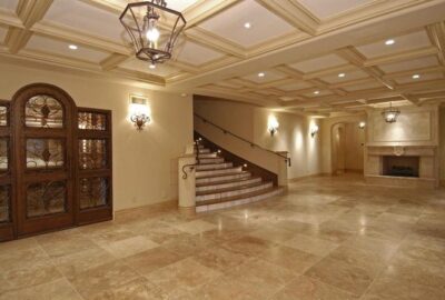 Grand foyer with polished marble tile floors, a coffered ceiling, ornate doors, and a marble staircase.