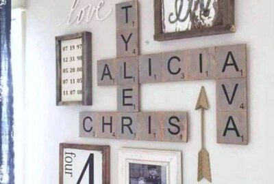Family wall collage with Scrabble tiles spelling Alicia, Chris, Ava, and Tyle, surrounded by rustic frames and signs.