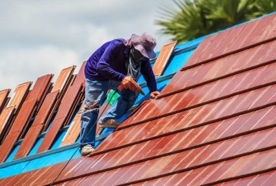 *   Image content: A person wearing a purple shirt, blue jeans, and a wide-brimmed hat is working on a roof.
    *   Action: