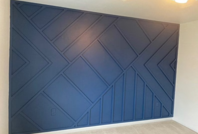 Interior wall with navy blue geometric wood paneling in a modern design.