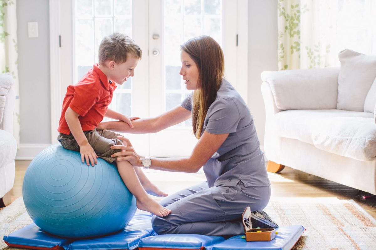 *   Image content: A woman in grey scrubs (likely a therapist or nurse) is working with a young boy in a red shirt.
    *   A
