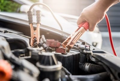 Close,Up,Of,Hand,Charging,Car,Battery,With,Electricity,Trough