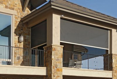 *   Image: A close-up of a balcony on a stone house.
    *   Key features: Stone walls, a black metal railing, a large window