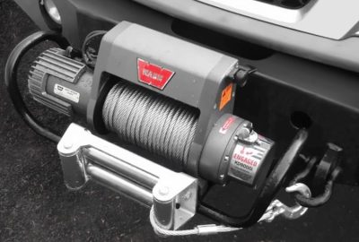 *   Image: A close-up of a vehicle winch mounted on a bumper.
    *   Key elements: Winch drum with steel cable, motor, fairl