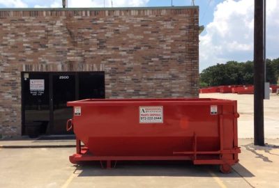 A roll-off container placed on the road, ready for waste collection and disposal.