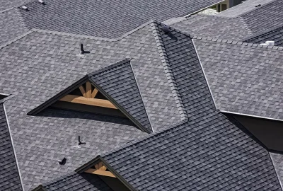 Grey asphalt shingle roofing on a complex roofline with multiple peaks and gables.