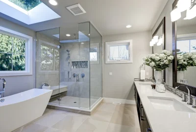 Modern bathroom featuring a white freestanding tub, glass walk-in shower, and double vanity with white countertops.