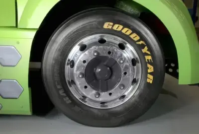 Close-up of a Goodyear tire and chrome wheel on a lime green truck.