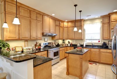 *   Image: A spacious kitchen.
    *   Key features: Light wood cabinets, dark granite countertops, stainless steel appliance