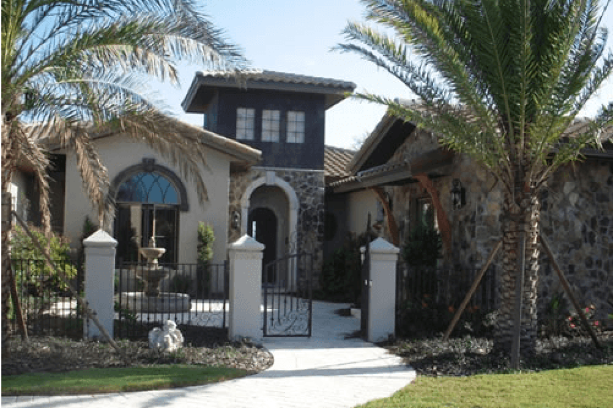 *   Image: A luxury home with a Mediterranean/Spanish style.
    *   Key elements:
        *   Stone and stucco walls.