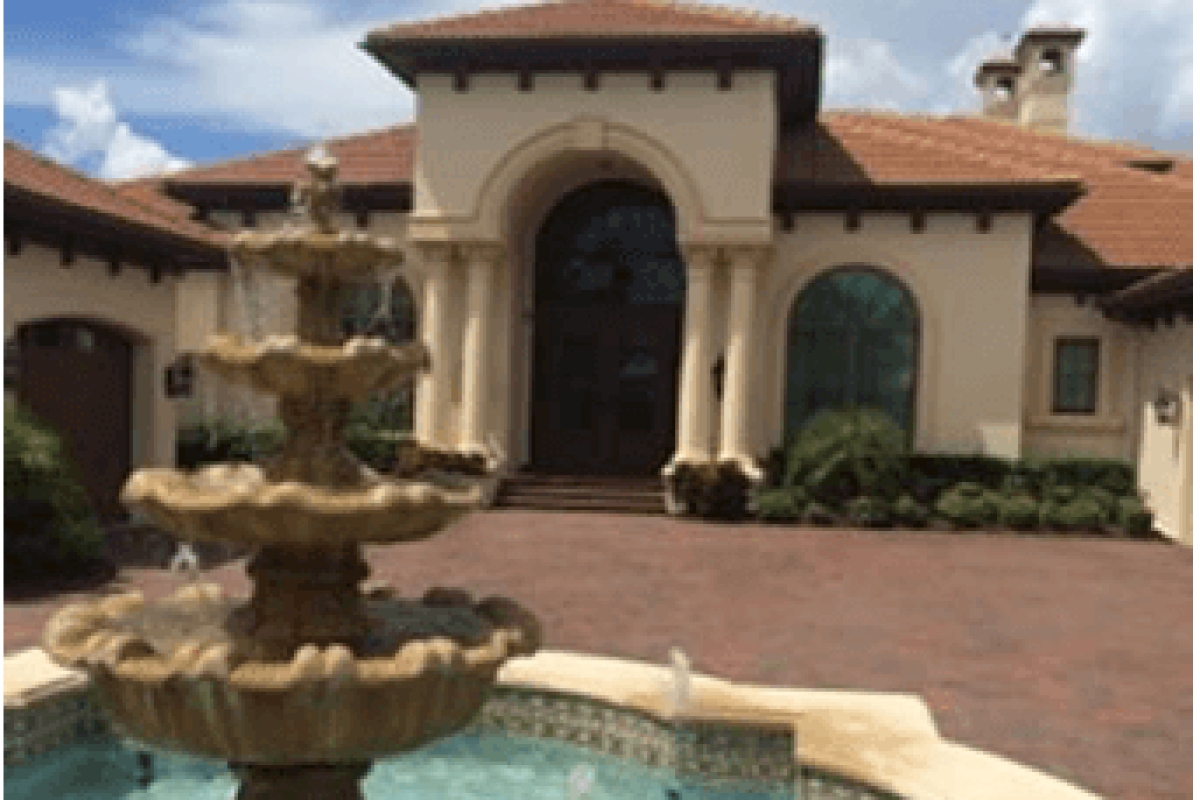 *   Image: A large, Mediterranean-style luxury home with a tiered stone fountain in the foreground.
    *   Key elements: Tie