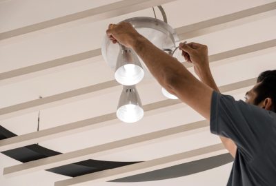 Electrical engineers are installing ceiling lamps in the hallway.