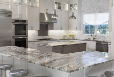 *   Image: A high-end, modern kitchen.
    *   Key elements:
        *   White upper cabinets.
        *   Grey/taupe lower c