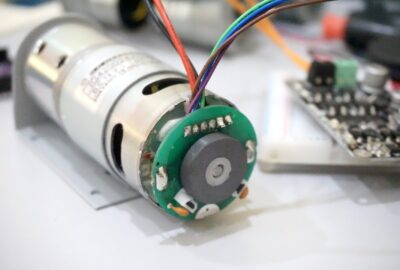 Silver DC motor with a green circular encoder board and multi-colored wiring.