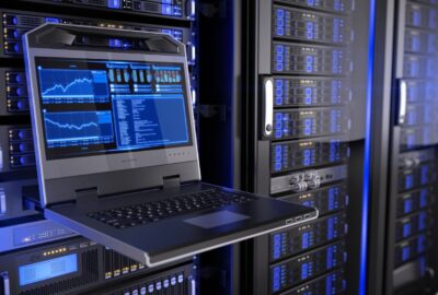 Rugged server console laptop displaying blue data graphs in a room with blue-lit server racks.
