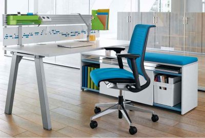 Modern white workstation featuring a blue ergonomic office chair and white storage unit with a blue seat.