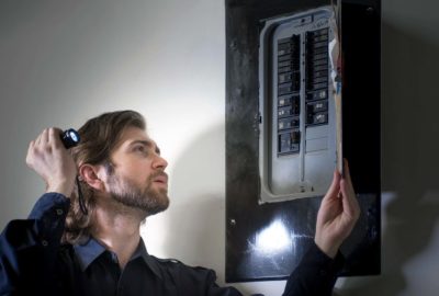 *   Image: A man with a beard and longish hair, wearing a dark blue shirt.
    *   Action: He is holding a small flashlight i