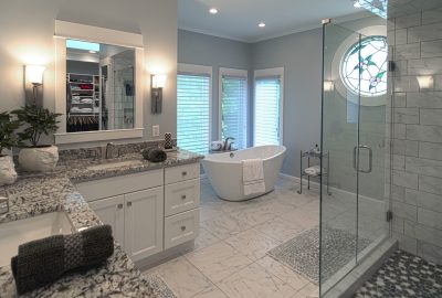 Modern bathroom with white cabinetry, granite countertops, a freestanding bathtub, and a glass walk-in shower.