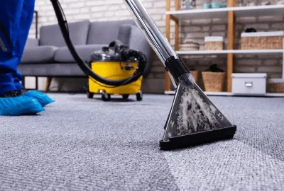 Professional carpet extractor cleaning a grey carpet.