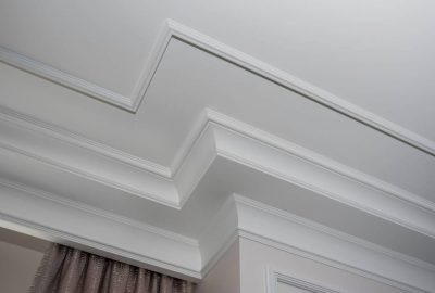 White multi-tiered crown molding on a decorative tray ceiling.