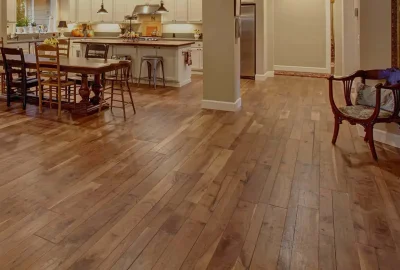 Wide-plank hardwood flooring in an open-concept living space with a dining area and kitchen.