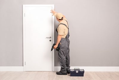 *   Image content: A man dressed as a handyman (tan shirt, grey overalls, tan cap) standing next to a white door.
    *   Act