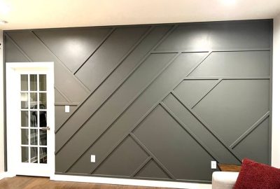 Dark gray accent wall with a geometric wood slat design next to a white French door.