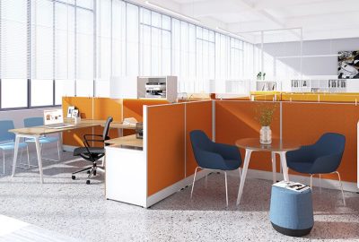 Modern open office with orange partitions, blue chairs, wooden desks, and large windows with white blinds.