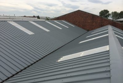 Grey corrugated metal roof with integrated white skylight panels.