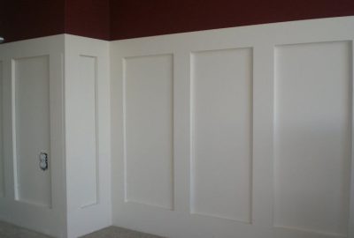 White board and batten wainscoting on a wall with a dark red upper section.