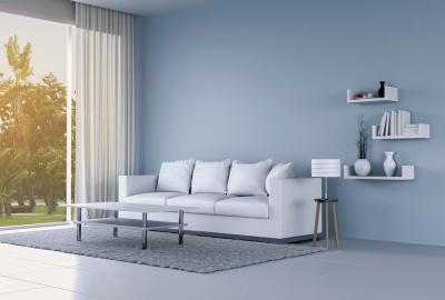 *   Image: A modern living room.
    *   Key elements: White sofa, white coffee table, grey rug, blue wall, white floating sh