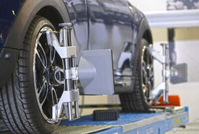 Wheel alignment sensors attached to the wheels of a car on a service lift.